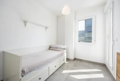 a white bedroom with a bed and a window at Conil Seaside Hideaway in Conil de la Frontera