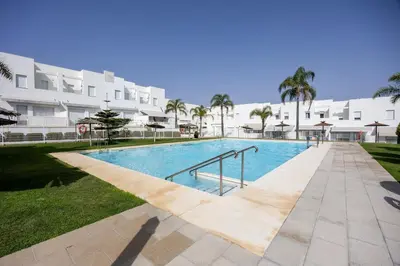 a swimming pool in front of a large building at Conil Seaside Hideaway in Conil de la Frontera