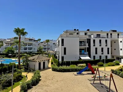 a playground in front of a building with a pool at Apartamento Brisa Candor - Ole Solutions in Rota