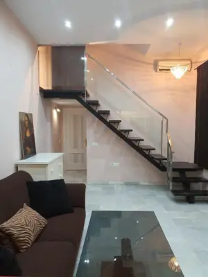 a living room with a couch and a staircase at Mina5 in Cádiz
