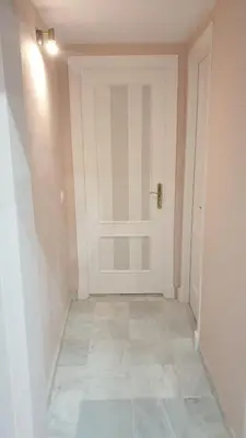 a hallway with a white door and a tile floor at Mina5 in Cádiz