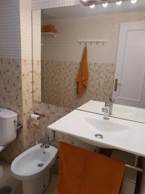 a bathroom with a sink and a toilet and a mirror at Mina5 in Cádiz