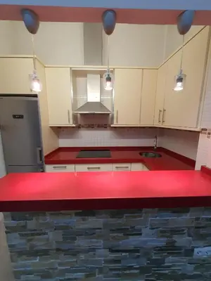 a kitchen with a red counter top and white cabinets at Mina5 in Cádiz