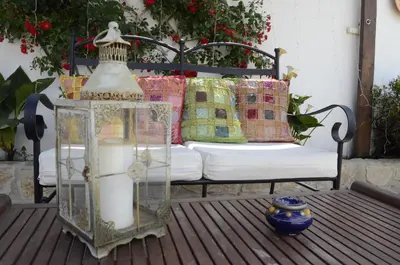 a bench with pillows and a glass container on a deck at Alojamiento Rural 