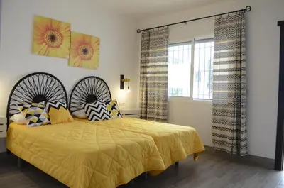 a bedroom with a bed with a yellow comforter and a window at Alojamiento Rural 