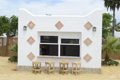 a small white house with three stools in front of it at Alojamiento Rural 