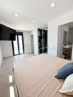 a bedroom with a large bed with a tv on the wall at Villa Foreber in Chiclana de la Frontera