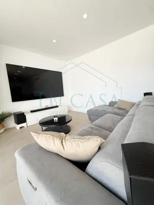 a living room with a couch and a large tv at Villa Foreber in Chiclana de la Frontera