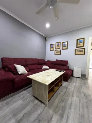 a living room with a red couch and a coffee table at Valdelagrana del Mar in El Puerto de Santa María