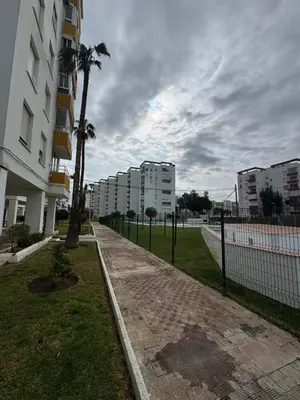 a sidewalk next to a building with a palm tree at Valdelagrana del Mar in El Puerto de Santa María