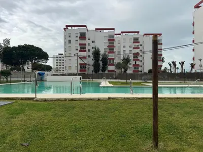 an empty swimming pool in a city with tall buildings at Valdelagrana del Mar in El Puerto de Santa María