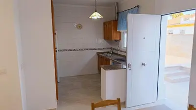 a kitchen with a white refrigerator in a room at Villa Juana in Conil de la Frontera