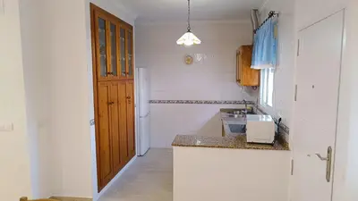a kitchen with a counter and a wooden door at Villa Juana in Conil de la Frontera