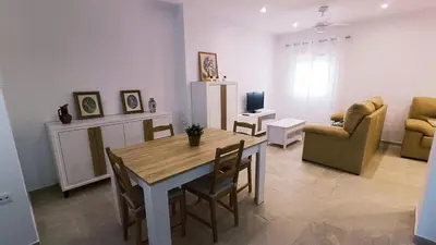 a living room with a table and chairs and a living room at Villa Juana in Conil de la Frontera
