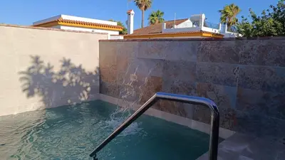 a swimming pool with a handrail in front of a house at Villa Juana in Conil de la Frontera