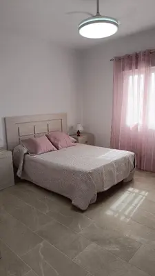 a bedroom with a large bed with pink pillows at Villa Juana in Conil de la Frontera