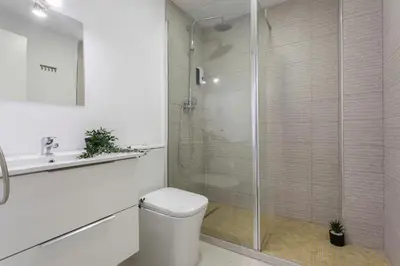 a bathroom with a shower and a toilet and a sink at Allo Apartments Morenos VI in Jerez de la Frontera