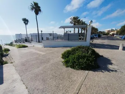 a parking lot with a gazebo next to the beach at Apartamento junto a PLAYA LAS REDES-VISTAHERMOSA, CADIZ in El Puerto de Santa María