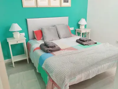 a bedroom with a bed with two tables and two lamps at Apartamento junto a PLAYA LAS REDES-VISTAHERMOSA, CADIZ in El Puerto de Santa María