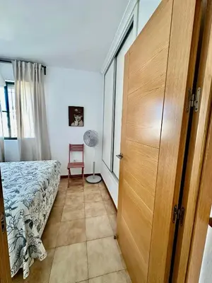 a bedroom with a bed and a wooden door at Barrosa Living in Chiclana de la Frontera
