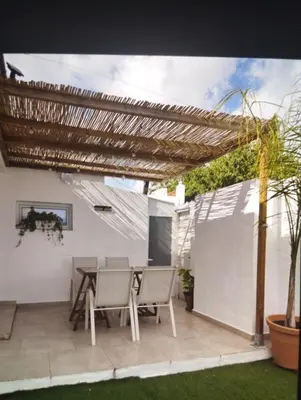 a patio with a table and chairs under a pergola at Estudio Álvaro in Cádiz