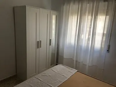 a bedroom with a bed and a white cabinet at Apartamento Relax junto al Mar in El Puerto de Santa María