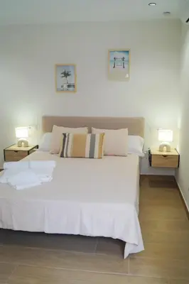 a bedroom with a large white bed with two night stands at Alojamientos Dunas del Alba in Chipiona