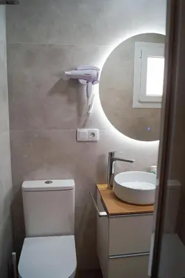 a bathroom with a white toilet and a sink at Alojamientos Dunas del Alba in Chipiona