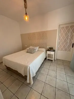 a bedroom with a bed and a tiled floor at Villa Marina in Chipiona