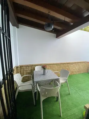 a table and chairs on a patio with green grass at Villa Marina in Chipiona