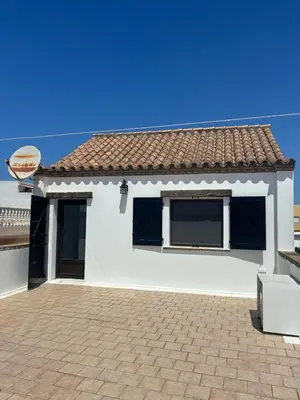 a white house with a window and a roof at Villa Marina in Chipiona