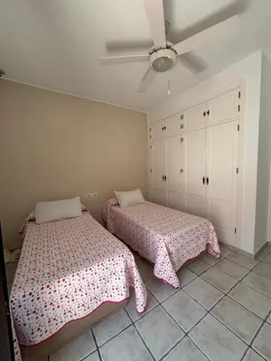a bedroom with two beds and a ceiling fan at Villa Marina in Chipiona