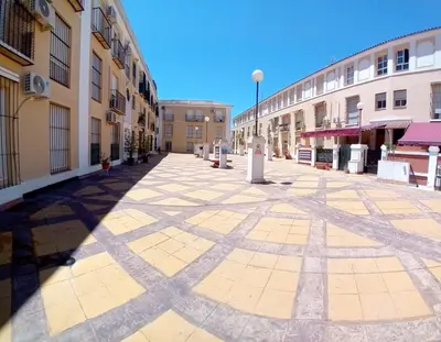 an empty street in a city with buildings at Castle in Sanlúcar de Barrameda