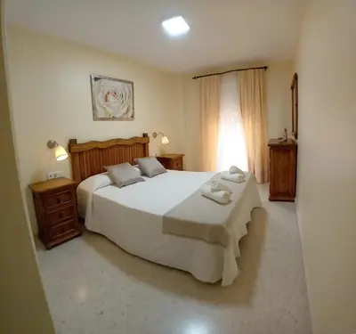 a bedroom with a large white bed and a window at Castle in Sanlúcar de Barrameda