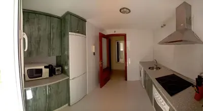 a kitchen with green cabinets and a red door at Castle in Sanlúcar de Barrameda
