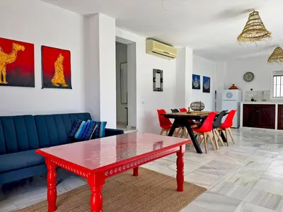 a living room with a blue couch and a red table at Casa Las Cumbres I - Ole Solutions in El Puerto de Santa María
