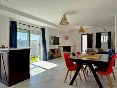 a kitchen and living room with a table and chairs at Casa Las Cumbres I - Ole Solutions in El Puerto de Santa María