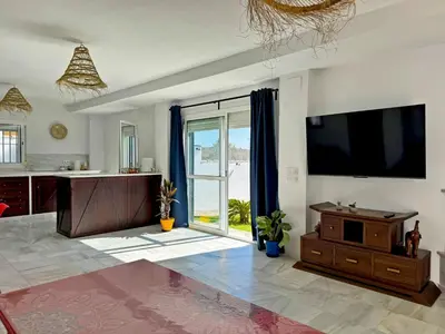 a living room with a tv and a large window at Casa Las Cumbres I - Ole Solutions in El Puerto de Santa María