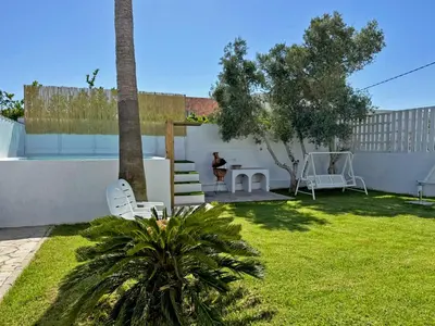 a backyard with a table and chairs and a palm tree at Casa Las Cumbres I - Ole Solutions in El Puerto de Santa María