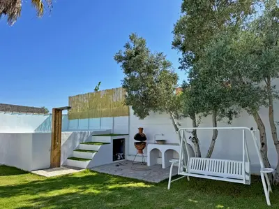 a person sitting at a table in a yard at Casa Las Cumbres I - Ole Solutions in El Puerto de Santa María