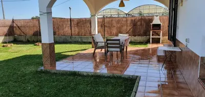 a living room with a tv and a coffee table at Casa con jardin privado en primera linea de playa in Chipiona