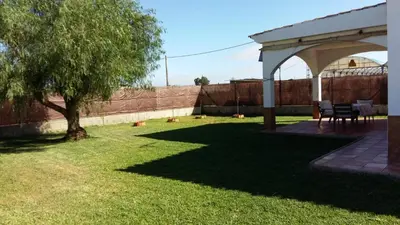 two orange trees in a yard next to a fence at Casa con jardin privado en primera linea de playa in Chipiona
