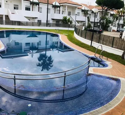 a large swimming pool in the middle of a building at Costa El Castillo La Barrosa in Poblado de Sancti Petri