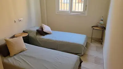 a room with two beds and a window at Costa El Castillo La Barrosa in Poblado de Sancti Petri