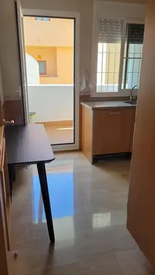 a kitchen with a table in the middle of a room at Costa El Castillo La Barrosa in Poblado de Sancti Petri