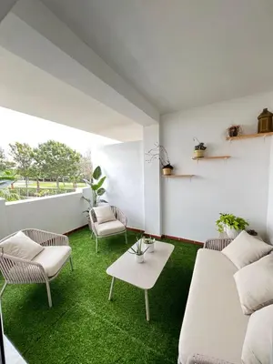a living room with white furniture and green grass at Housfy Beach Costa Ballena by Sanlúcar Housing in Chipiona