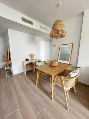 a dining room with a wooden table and chairs at Housfy Beach Costa Ballena by Sanlúcar Housing in Chipiona
