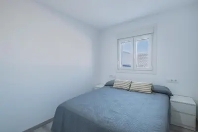 a bed in a white room with a window at Villa Kaki in Conil de la Frontera