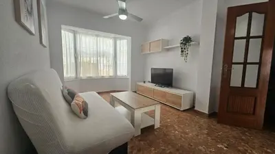 a living room with a couch and a tv and a table at Camaron Beach House By Sanlúcar Housing in Chipiona