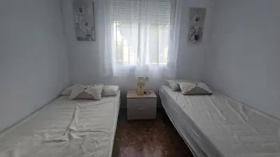 two beds in a small room with a window at Camaron Beach House By Sanlúcar Housing in Chipiona
